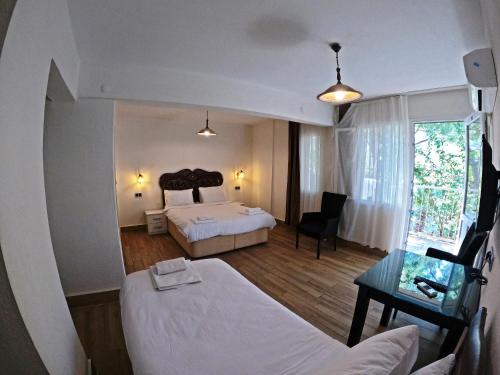 Habitación de hotel con cama, escritorio y habitación en Atillas Getaway, en Selçuk