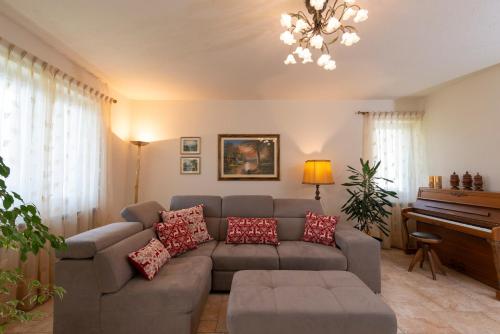 ein Wohnzimmer mit Sofa und Klavier in der Unterkunft Villa Mara - Aosta - 200 mq - WiFi - Jacuzzi - Parcheggio - Giardino in Aosta