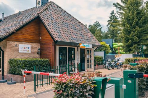 a small wooden building with flowers in front of it at EuroParcs De Utrechtse Heuvelrug in Maarn