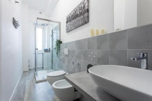 - une salle de bains blanche avec 2 toilettes et un lavabo dans l'établissement Sulla via del treno by Wonderful Italy, à Turin