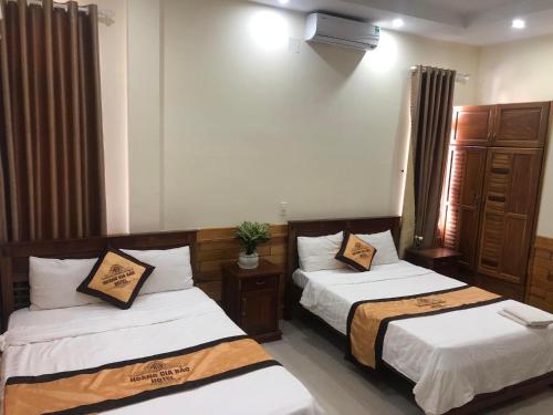 a bedroom with two beds and a window at Hoàng Gia Bảo Hotel in Kon Tum