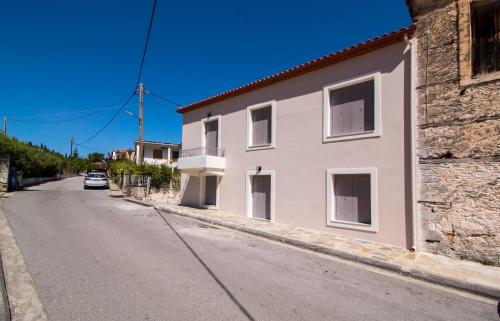 a white building on the side of a street at Mystras Residence Ground Floor in Mystras