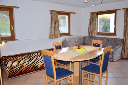 ein Esszimmer mit einem Tisch, Stühlen und einem Sofa in der Unterkunft Villa Kuntner Bund in Tschierv