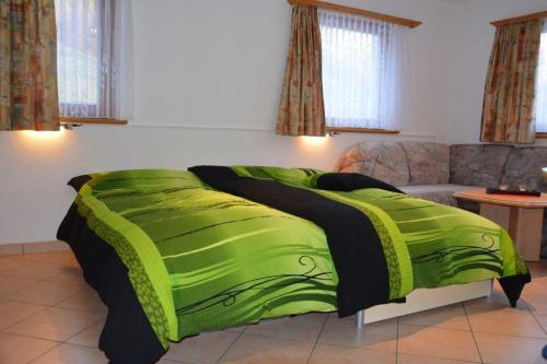 斯厄夫斯的住宿－Villa Kuntner Bund，一张绿床,位于一个配有沙发的房间