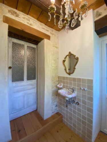 une salle de bain avec un lavabo et un miroir dans l'établissement Paradis Fleuri et son bain nordique, à Chaussy