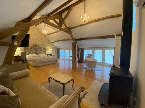 - un grand salon avec un canapé et une cuisinière dans l'établissement Paradis Fleuri et son bain nordique, à Chaussy