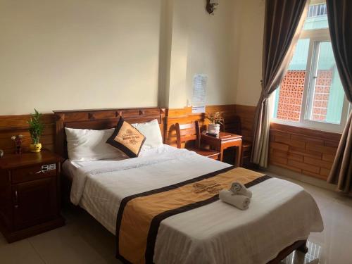 a bedroom with a bed with a heart pillow on it at Hoàng Gia Bảo Hotel in Kon Tum