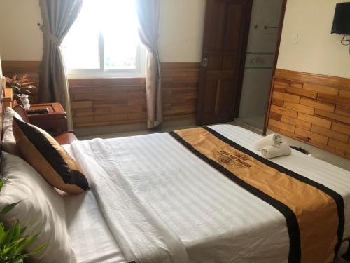 a bedroom with a large bed with a stuffed animal on it at Hoàng Gia Bảo Hotel in Kon Tum