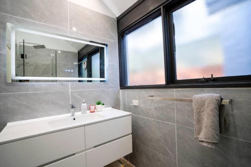 a bathroom with a sink and a mirror at Tranquil bush resort house - pool & fire pit in Pymble