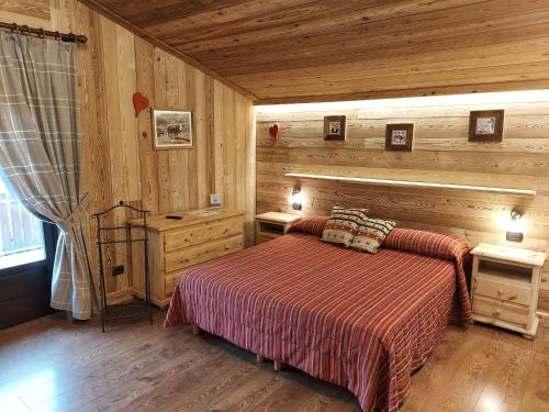 アイマヴィルにあるHotel Rendez-Vous - Aymavillesの木製の部屋にベッド1台が備わるベッドルーム1室があります。