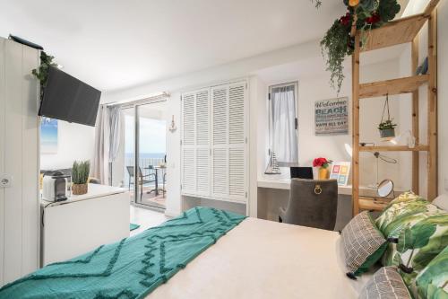 a bedroom with a bed and a desk with a view of the ocean at Funchal Sea View I by An Island Apart in Funchal