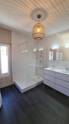 La salle de bains est pourvue d'une douche, d'un lavabo et d'un lustre. dans l'établissement La Fario - Grande maison familiale, à Font-Romeu-Odeillo-Via