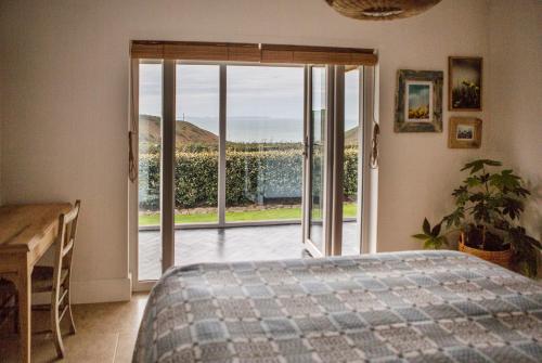 a bedroom with a bed and a sliding glass door at Swn Y Don in Haverfordwest