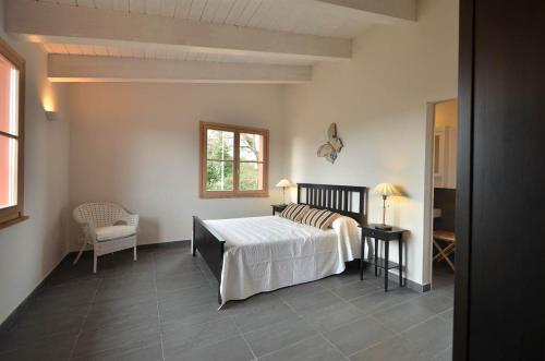 een slaapkamer met een bed, een stoel en een raam bij Superior apartment with terrace in Petroio