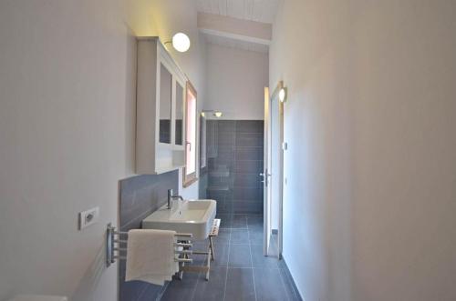 uma casa de banho com um lavatório branco e um espelho. em Superior apartment with terrace em Petroio