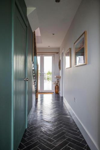 a hallway with a door and a tile floor at Swn Y Don in Haverfordwest