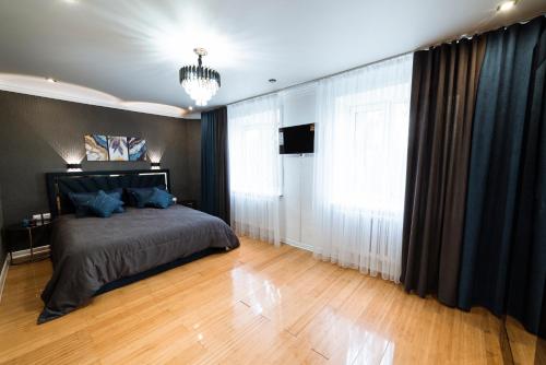 a bedroom with a bed and a large window at Сдам 2-х комнатную квартиру посуточно in Uralsk