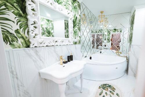 Baño blanco con lavabo y espejo en Сдам 2-х комнатную квартиру посуточно, en Uralsk