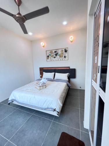 une chambre avec un lit et un ventilateur de plafond dans l'établissement 608 Ocean View 3 bedrooms, à Kuah