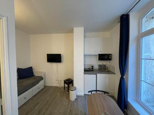 ein kleines Zimmer mit einem Bett und einer Küche in der Unterkunft Studio Le Galet idéalement situé en centre ville in Dieppe