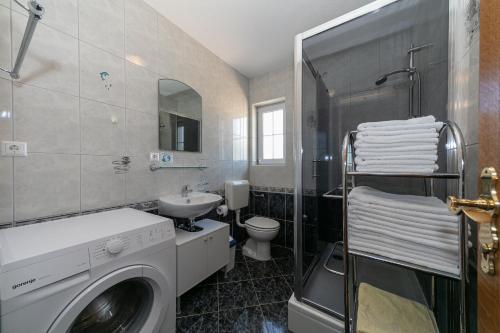 a bathroom with a washing machine and a sink at "Mare et Sol" apartments in Sveti Filip i Jakov