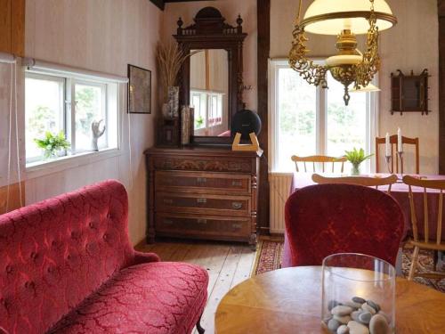 a living room with a red couch and a table at En lantlig idyll med skogen precis utanför dörren! in Ullared