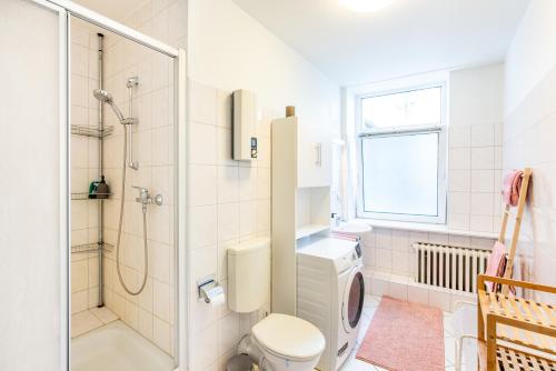 a white bathroom with a shower and a toilet at Gemütliches Apartment im Herzen Kiels in Kiel