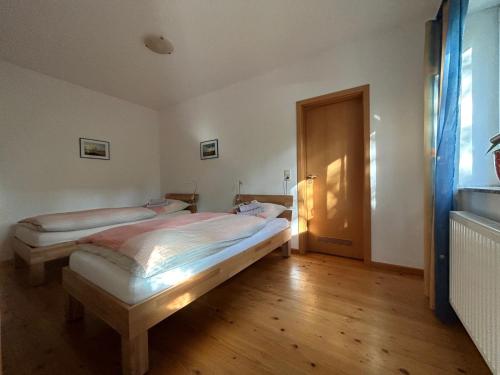 a bedroom with two beds and a wooden floor at Ferienwohnung Mayer in Rangsdorf