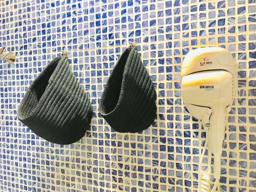 three hair dryers are hanging on a tile wall at La Casa di Litz in Naples