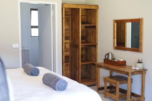 een slaapkamer met 2 bedden, een bureau en een spiegel bij Waterberg Game Lodge in Bela-Bela