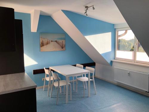 ein Esszimmer mit einem weißen Tisch und Stühlen in der Unterkunft Monteur-Pension W8 in Bad Schmiedeberg