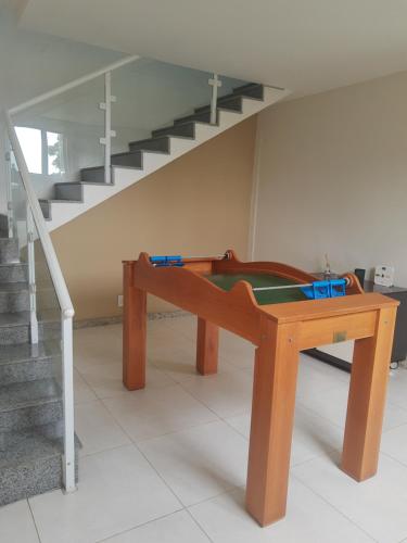 uma mesa de pingue-pongue num quarto com escadas em Buganville House Cabo Frio no Rio de Janeiro