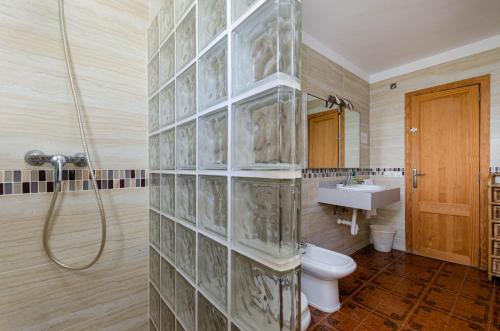 y baño con ducha, aseo y lavamanos. en YourHouse Ca Na Teulera, villa with private pool, en Can Picafort