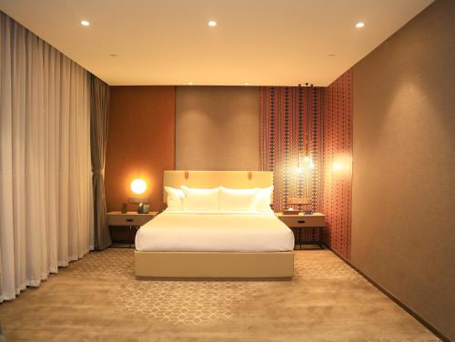1 dormitorio con 1 cama con almohadas blancas en Skylight In-Terminal Hotel en Addis Abeba