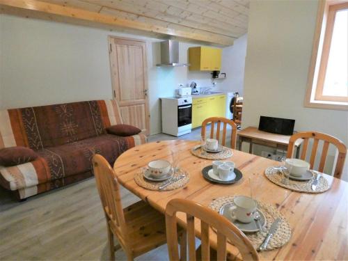 une cuisine et une salle à manger avec une table et des chaises en bois dans l'établissement La Maison des Eyres - Chambres, à Pey