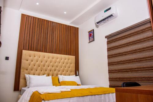 een slaapkamer met een bed met een groot hoofdeinde bij NIFEWAT APARTMENT,Bris suite 1bedroom apartment gym, Netflix,WiFi in Abuja