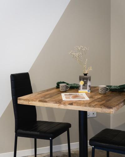 a wooden table with two black chairs and a table with a wooden table at Le Patio - Vallée d'Aspe in Bedous