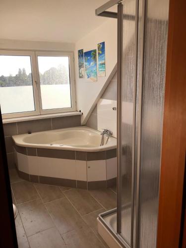 a bathroom with a bath tub and a window at Monteur-Pension W8 in Bad Schmiedeberg