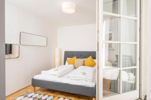 a mirror in a room with a bed with yellow pillows at Zum Grazer Uhrturm in Graz
