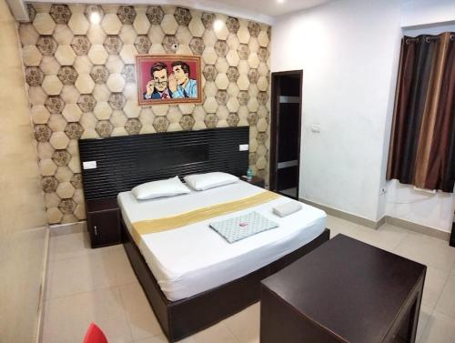 a bedroom with a bed and a picture on the wall at Hotel Karnal Inn in Karnal