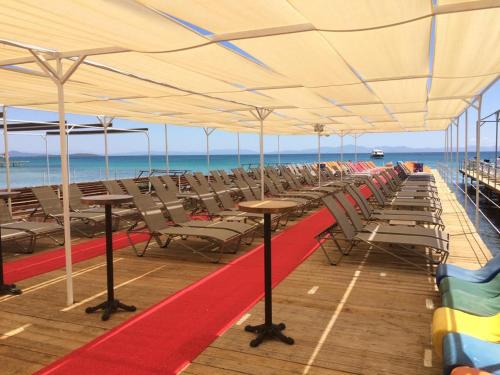 a row of tables and chairs under a canopy on the beach at THE LEA HOTELS & SUITE in Didim