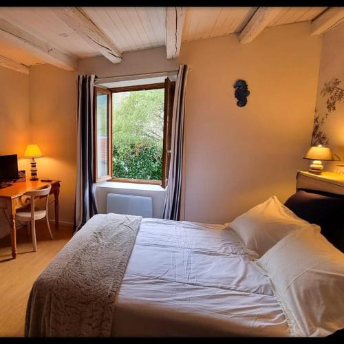une chambre avec un lit, une fenêtre et un bureau dans l'établissement Les Jardins de Kuz - Baleine, à Bernin
