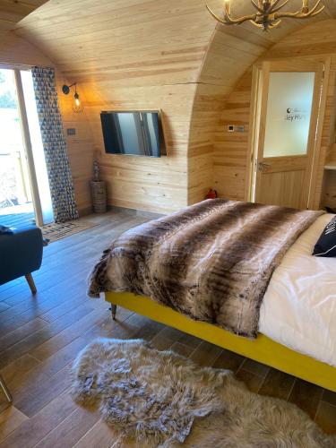 a bedroom with a large bed in a room with wooden walls at Cliff Stud Retreat - Luxury lodges and cosy cottages in Helmsley