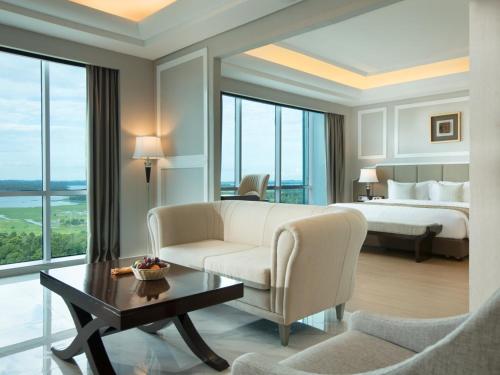 a hotel room with a bed and a couch and a table at Wyndham Panbil Batam in Batam Center
