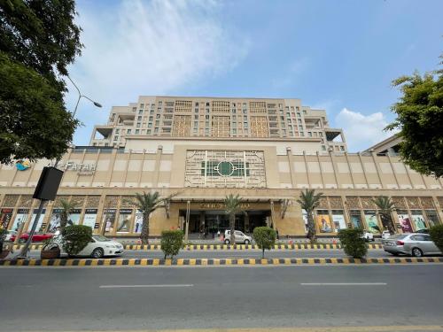 un gran edificio con coches estacionados frente a él en Luxury 1 Bedroom Apartment Gold Crest Mall And Residency DHA en Lahore