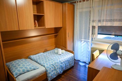 een kleine kamer met een bed, een bureau en een raam bij Apartment Maca Bled in Bled
