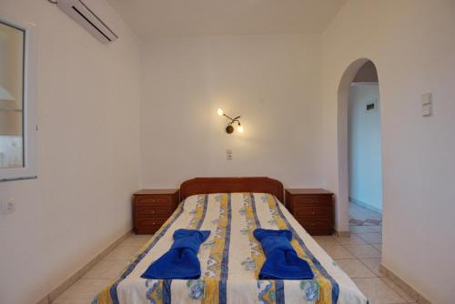 a bedroom with a bed with blue robes on it at Thea Studios in Kalamakia