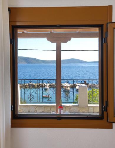 a window with a view of the water at Thea Studios in Kalamakia