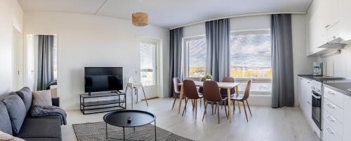 a kitchen and living room with a table and chairs at Apartment, SleepWell, Kirstinpuisto in Turku