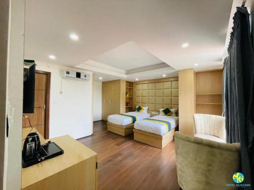 pokój hotelowy z 2 łóżkami i telewizorem w obiekcie Hotel Mustang Holiday Inn w Katmandu